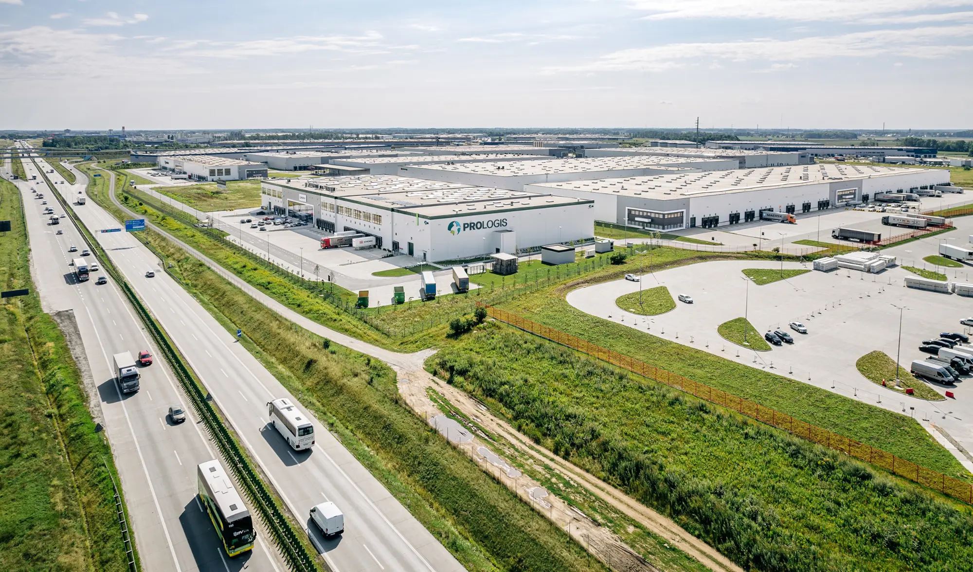 Letecký pohľad na moderný logistický park Prologis pri diaľnici s kamiónmi a skladovými halami